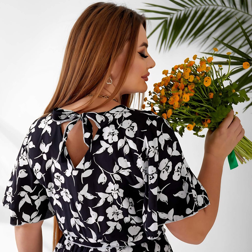 Plus size playsuit in black floral, back view in lifestyle setting — sharm
