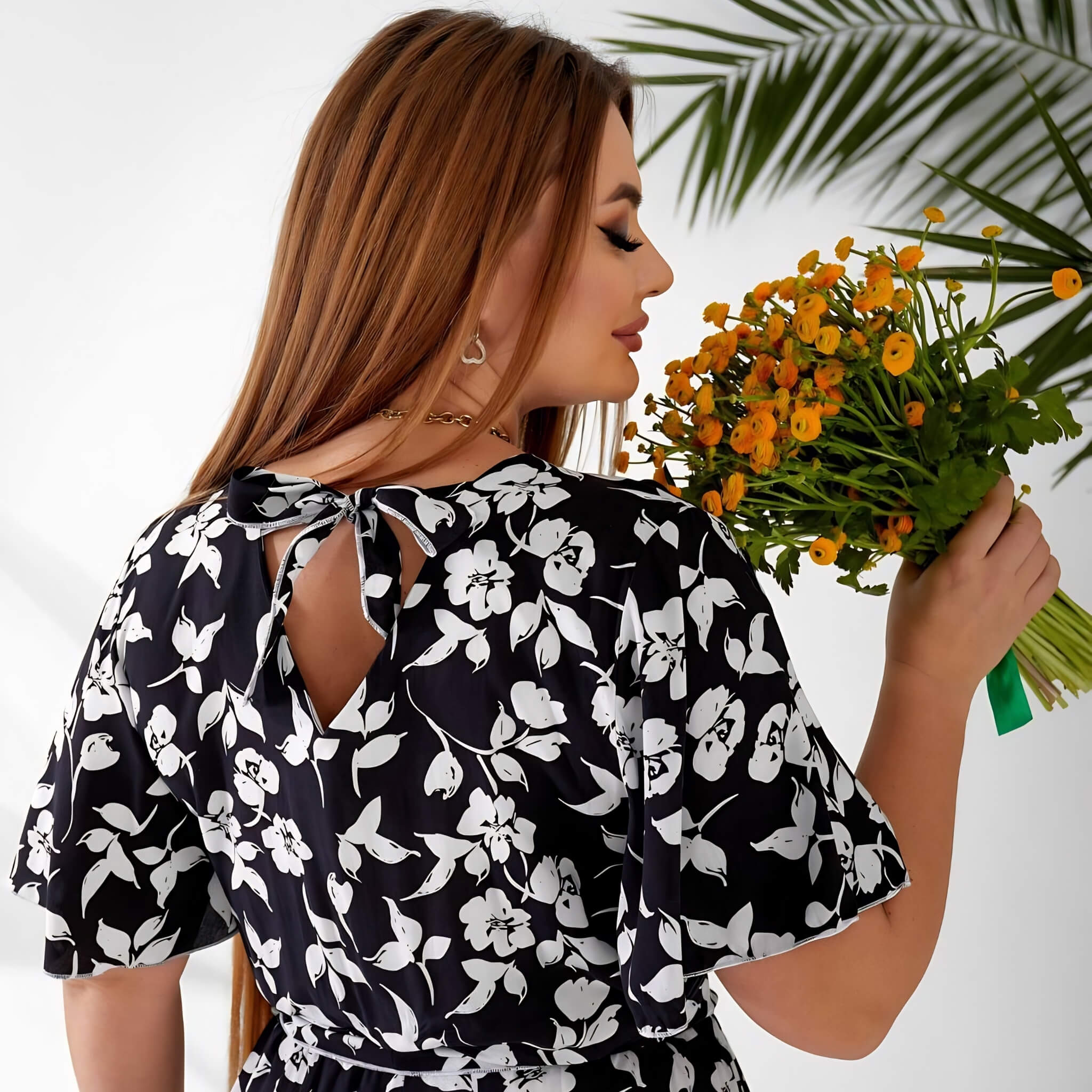 Plus size playsuit in black floral, back view in lifestyle setting — sharm