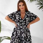 Plus size playsuit in black floral print, front view on model — sharm