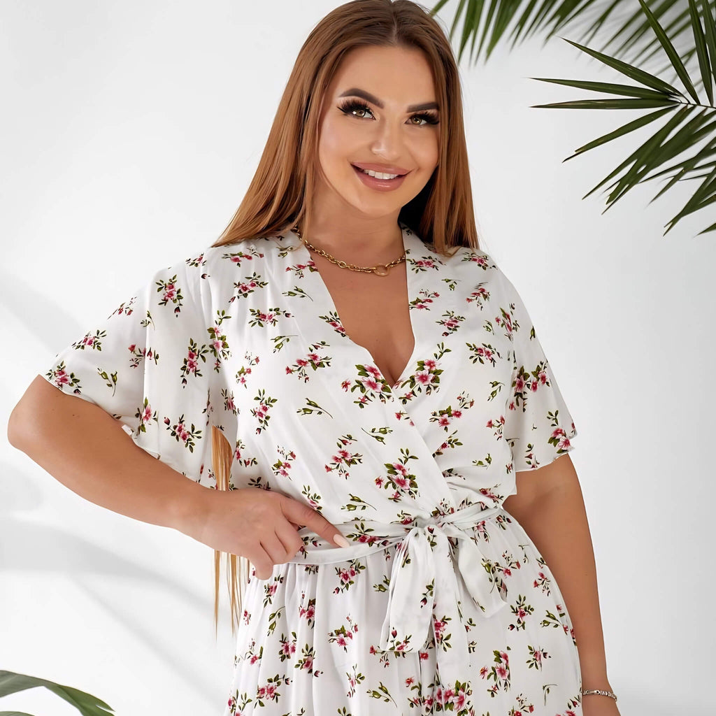 Plus size white floral playsuit, three-quarter view showing flutter sleeves — sharm