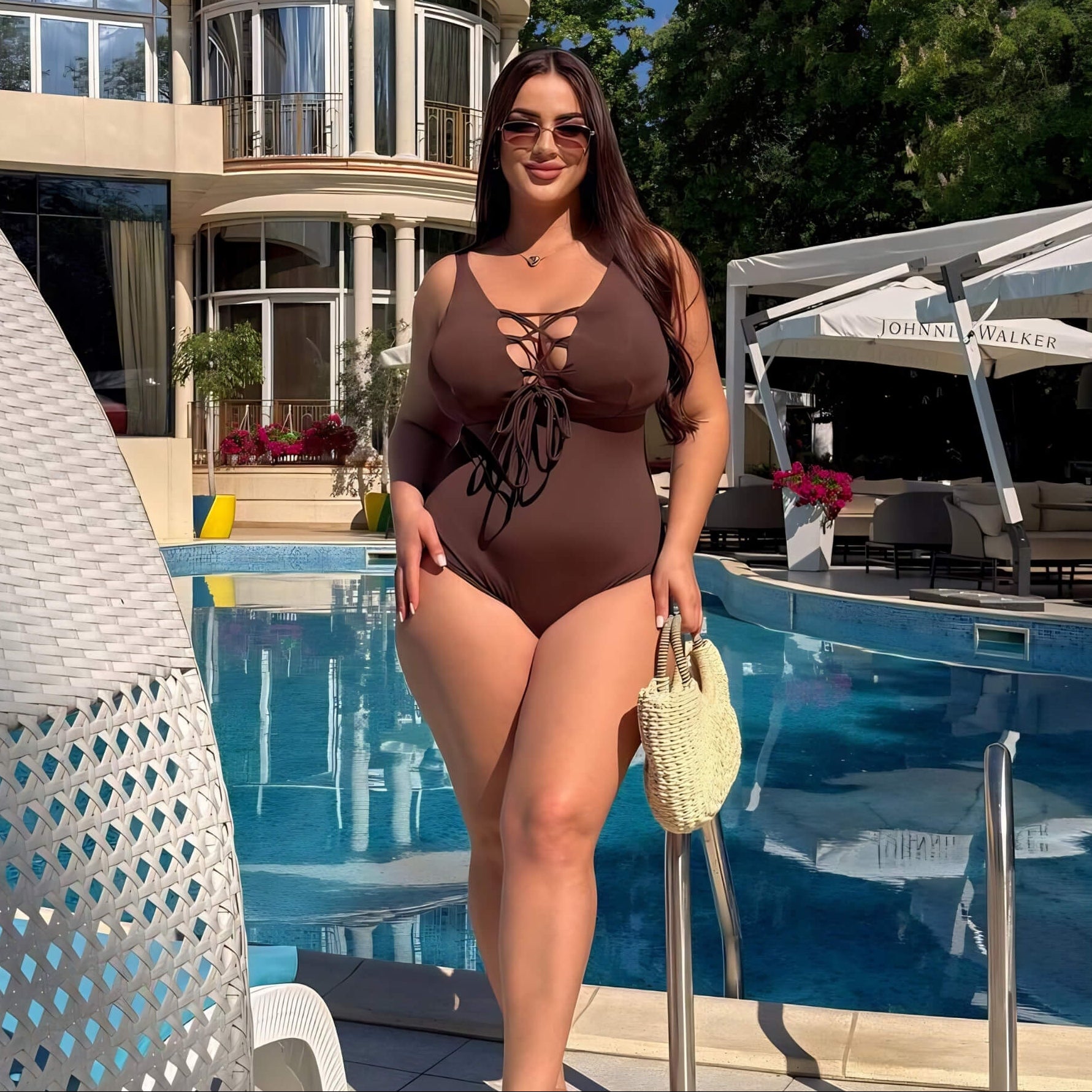 Plus size one-piece swimsuit in chocolate brown with lace-up front, full body at poolside — sharm