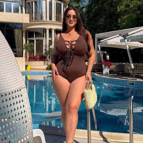 Plus size one-piece swimsuit in chocolate brown with lace-up front, full body at poolside — sharm